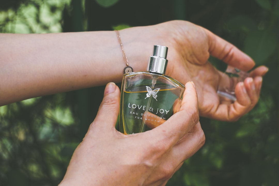 A wrist with a small drop of perfume catching the light