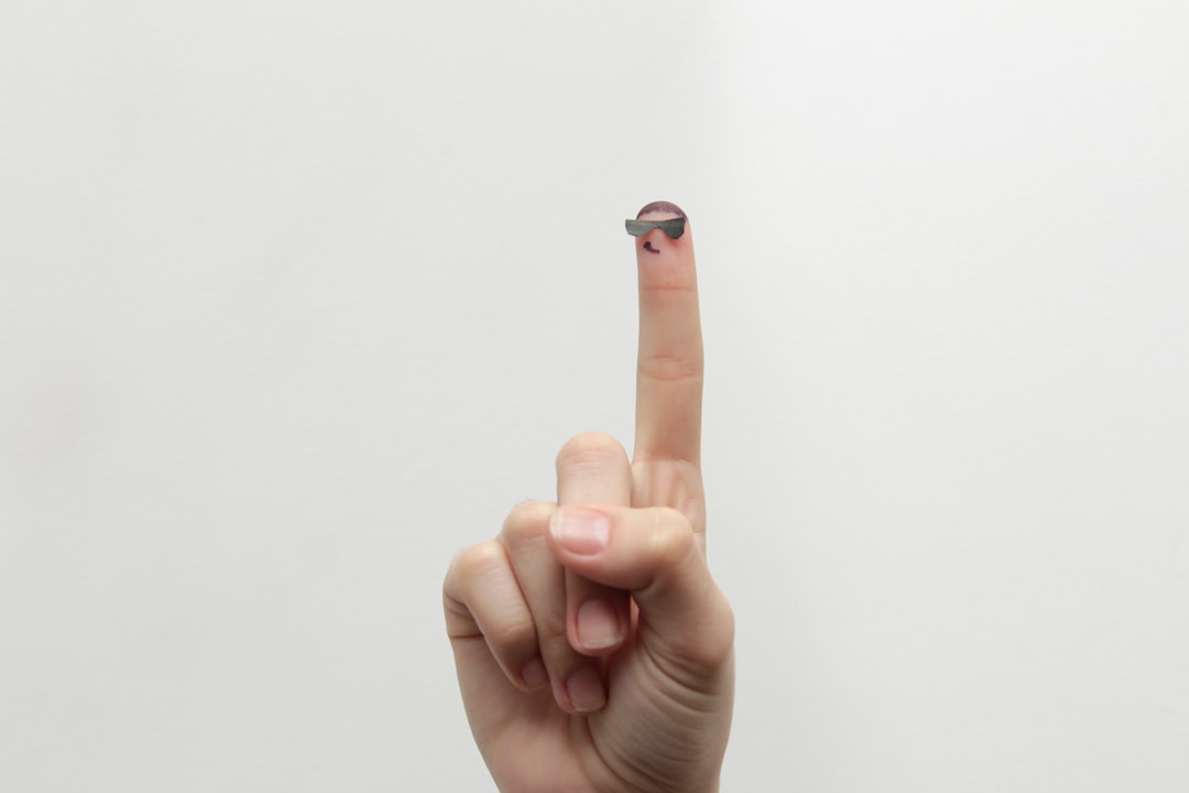 A fingertip lifting a trace of solid balm from a small tin